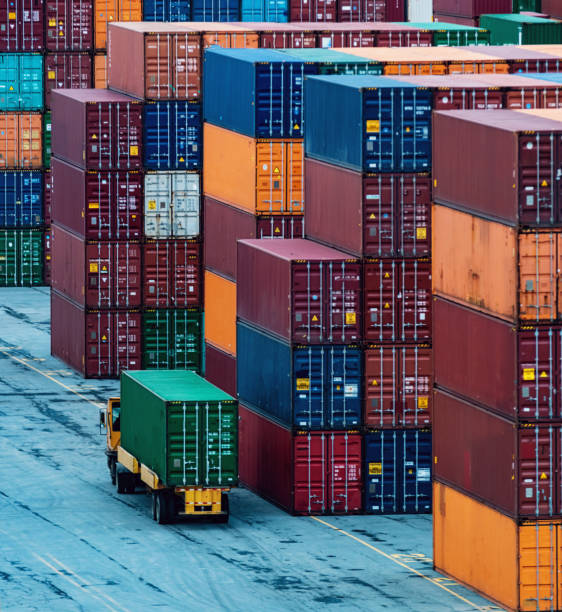 Stacked shipping containers with a reflection on the ground